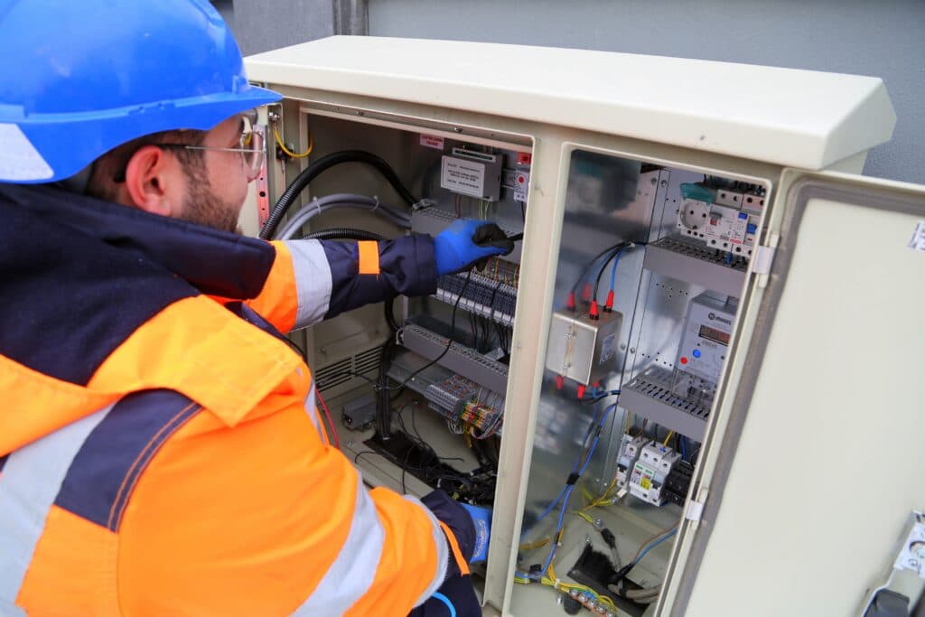 Roofpower-Techniker bei der Elektroinstallation an einem Schaltschrank